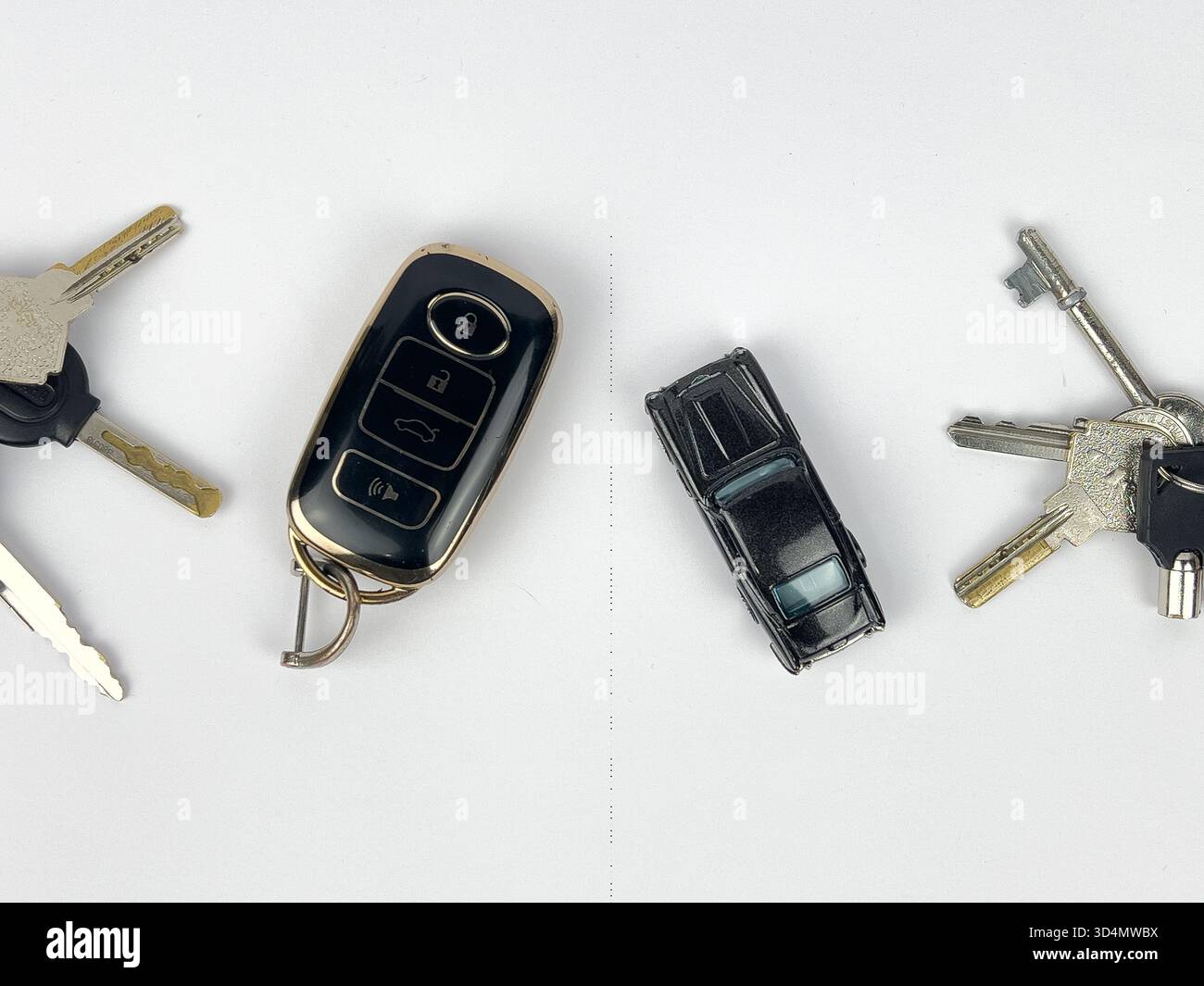 Dieses Bild zeigt eine Sammlung von Gegenständen zu Schlüsseln und Transport, die auf einer sauberen, weißen Oberfläche angeordnet sind, wahrscheinlich eine flache Lage oder eine Top-Down-Aufnahme. Stockfoto