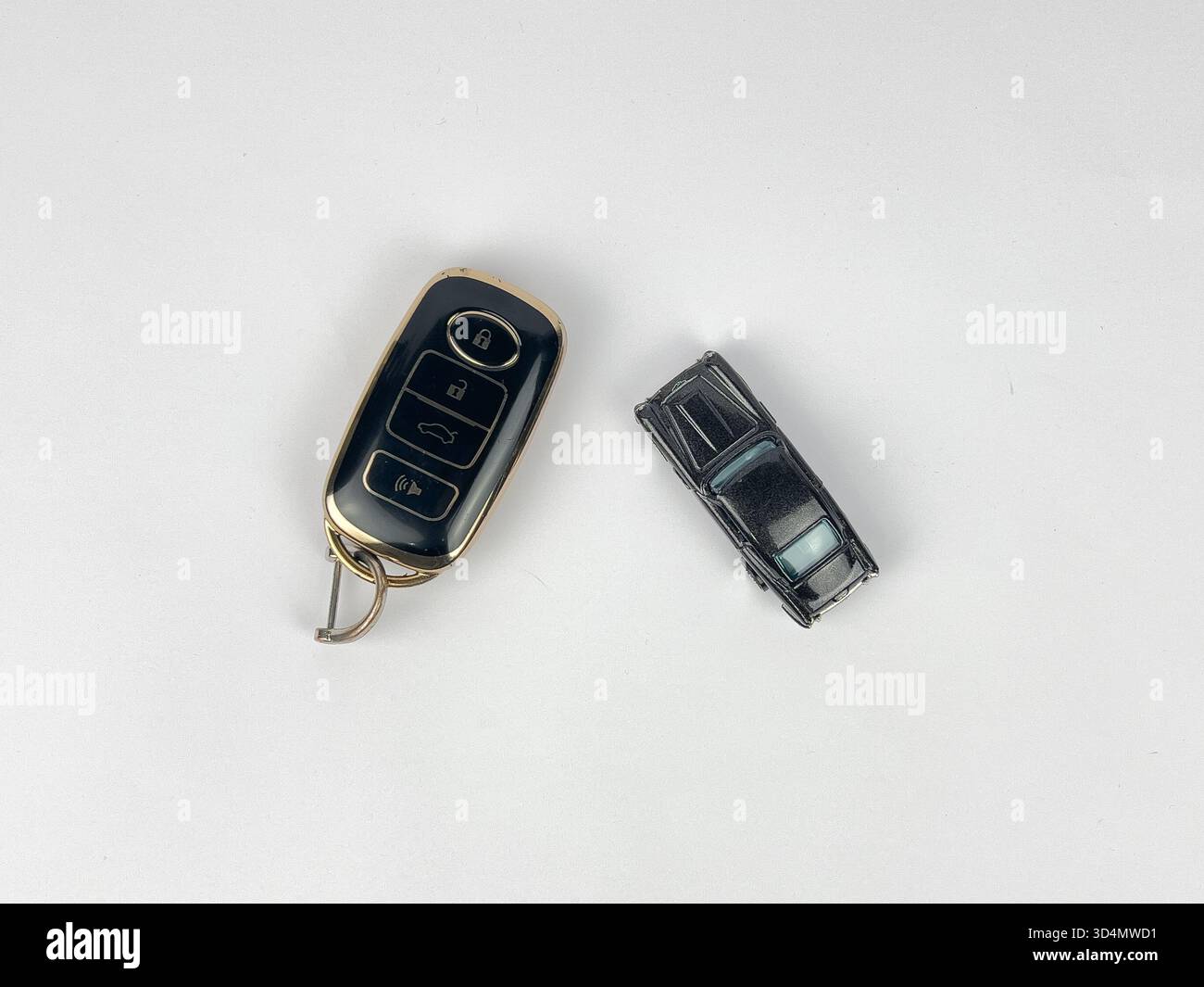 Dieses Bild zeigt eine Sammlung von Gegenständen zu Schlüsseln und Transport, die auf einer sauberen, weißen Oberfläche angeordnet sind, wahrscheinlich eine flache Lage oder eine Top-Down-Aufnahme. Stockfoto