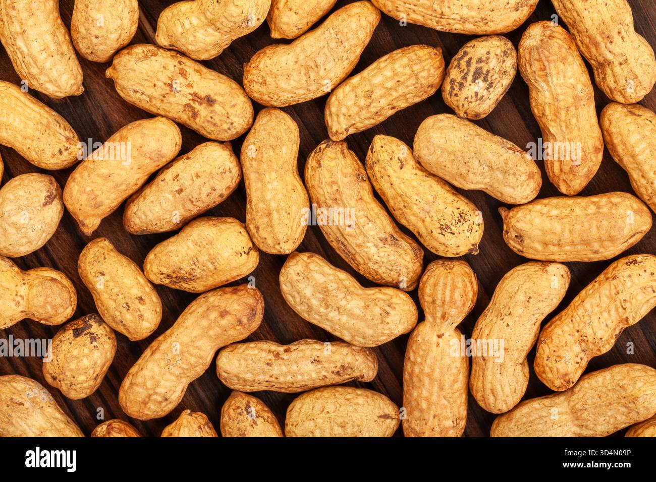 Erdnussstruktur auf Holzhintergrund Draufsicht Stockfoto