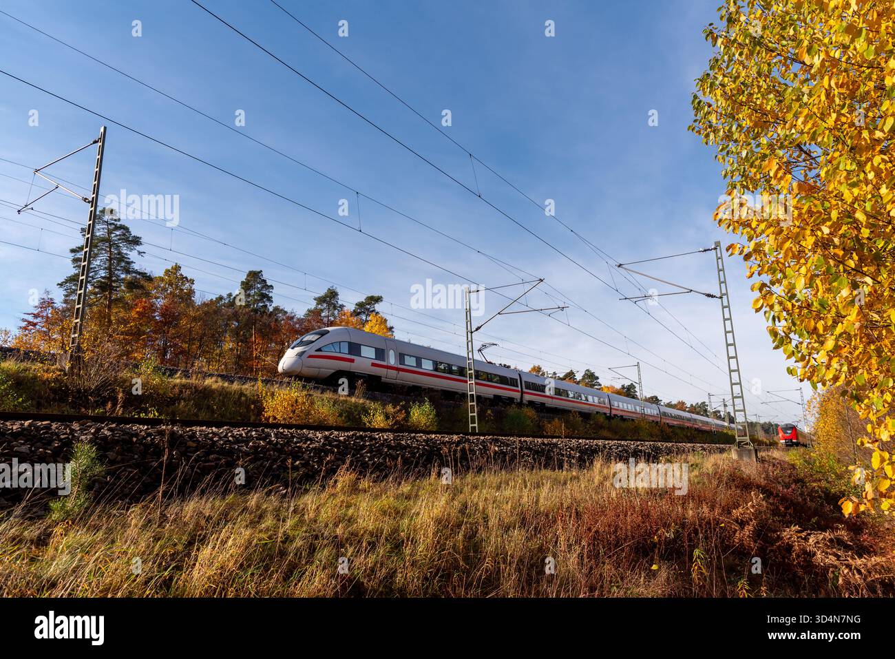 Deutscher Hochgeschwindigkeitszug, der an einem sonnigen Herbsttag fährt Stockfoto
