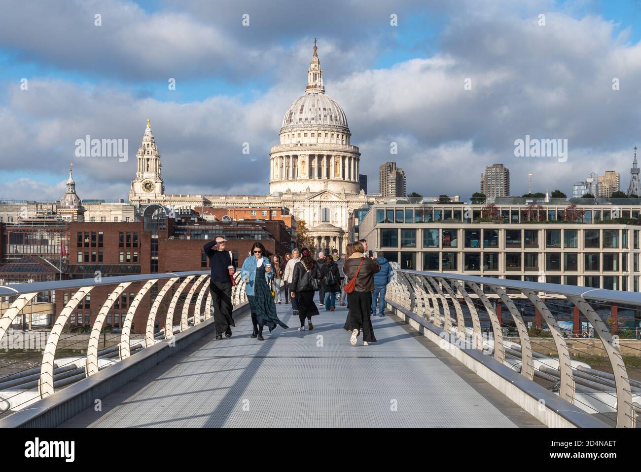 Menschen, die über die London Millennium Footbridge, auch Wackelbrücke genannt, laufen, London, England, Großbritannien, mit St Paul's Cathedral Stockfoto
