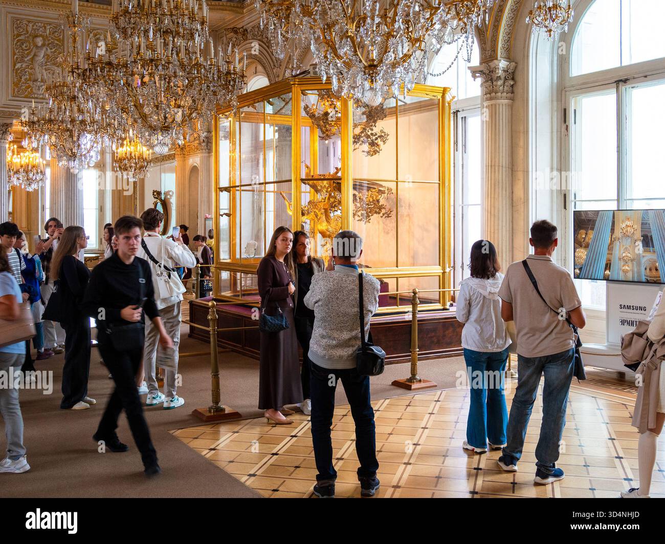 Sankt Petersburg, Russland - 22. August 2025: Touristen in der Nähe der Pfauenuhr im Zimmer des Eremitage-Museums in Sankt Petersburg Stadt am Sommertag Stockfoto
