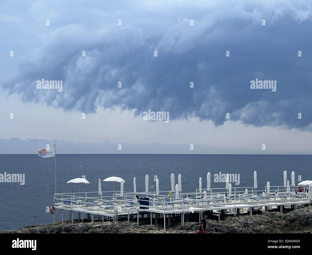 Leerer Ferienort am Wasser an einem bewölkten Tag in Andrano, Italien. Stockfoto