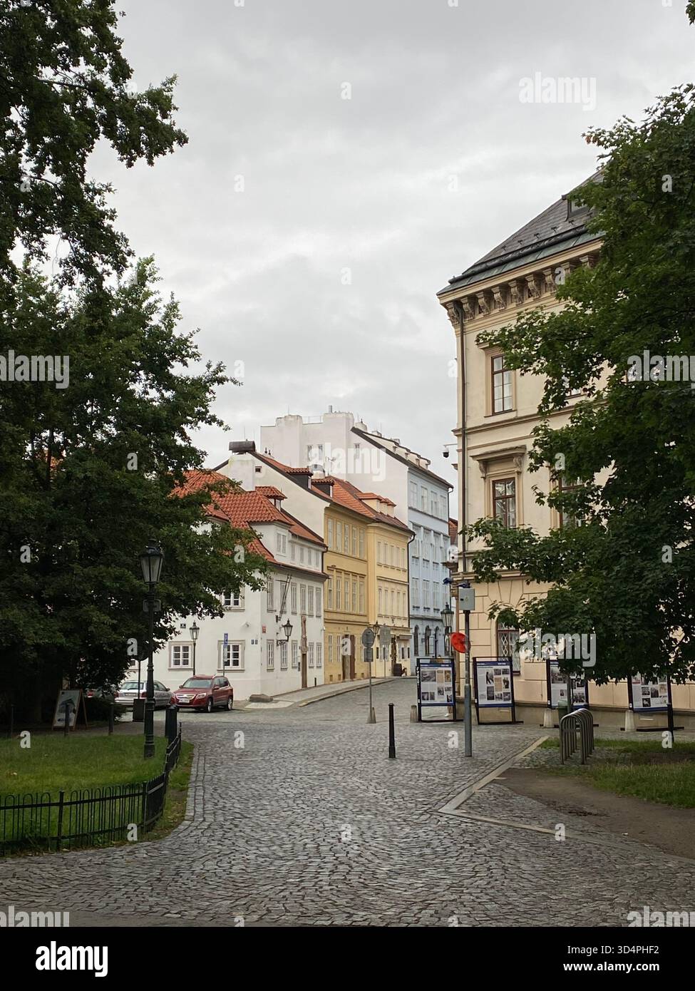 Ruhige kopfsteingepflasterte Straße mit farbenfrohen historischen Gebäuden an einem bewölkten Tag - Smartphone-aufgenommenes Stockfoto