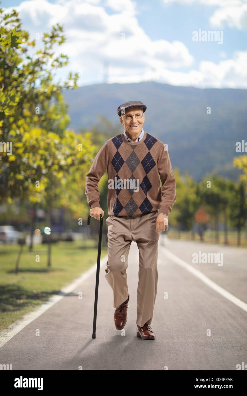 Porträt eines älteren Mannes mit einem Stock, der in einem Park spaziert Stockfoto