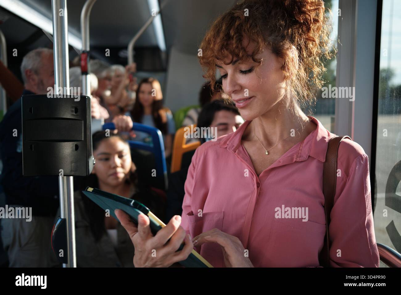 Pendlerin mit Tablet im Bus öffentlicher Verkehrsmittel Stockfoto