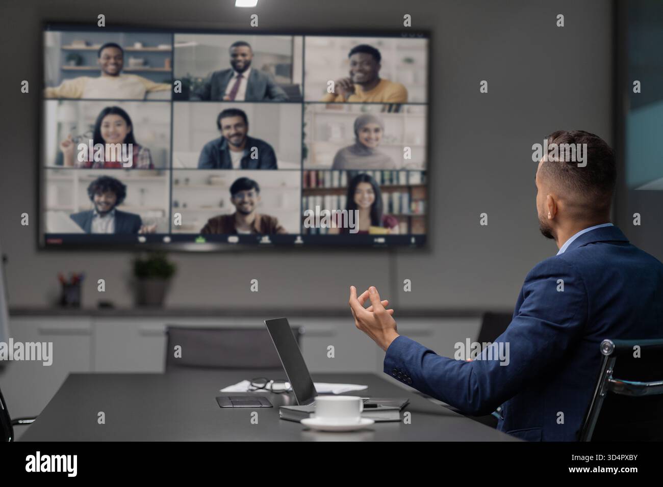 CEO leitet Videokonferenz mit diversen Teams während der COVID-19-Pandemie in Modern Office Stockfoto