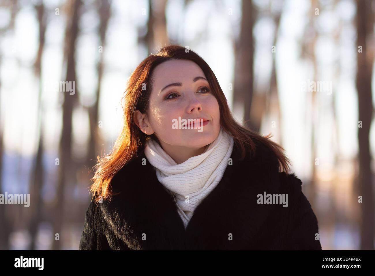 Niedliche Frau im Pelzmantel in einem Winterpark. Menschen Stockfoto