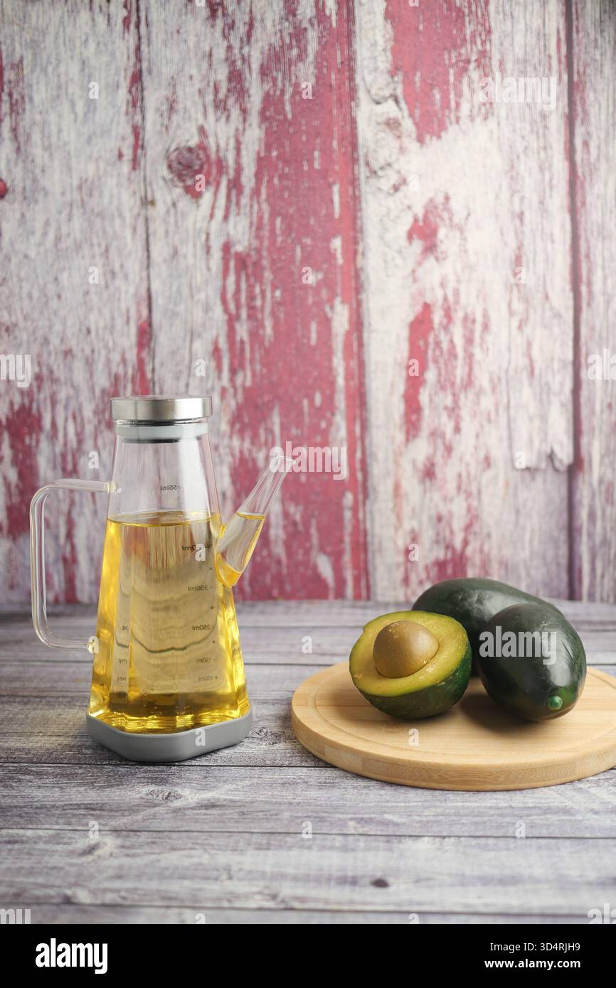 Öl und Avocado auf einem Holztisch in einer rustikalen Küche Stockfoto