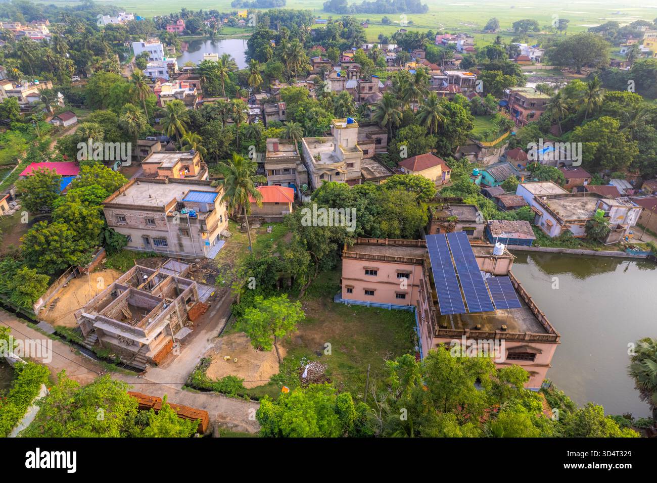 Drohnenaufnahme der Dachkonstruktion von Solarpaneelen in einem Wohngebiet, umgeben von Grün in Indien. Stockfoto