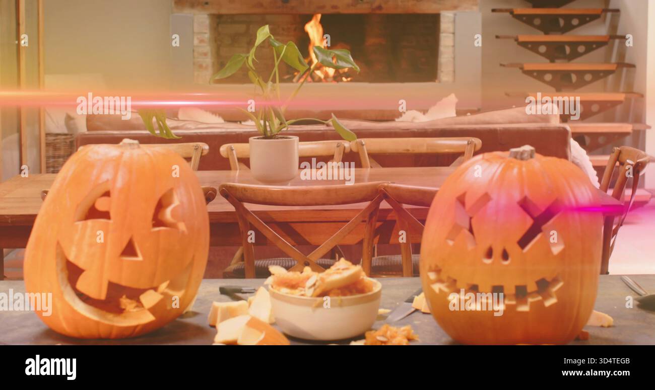 Glühende zwei geschnitzte Kürbisse, die zu Hause auf der Tischplatte liegen, mit einer Schüssel mit Därmen und Samen, Werkzeug Stockfoto