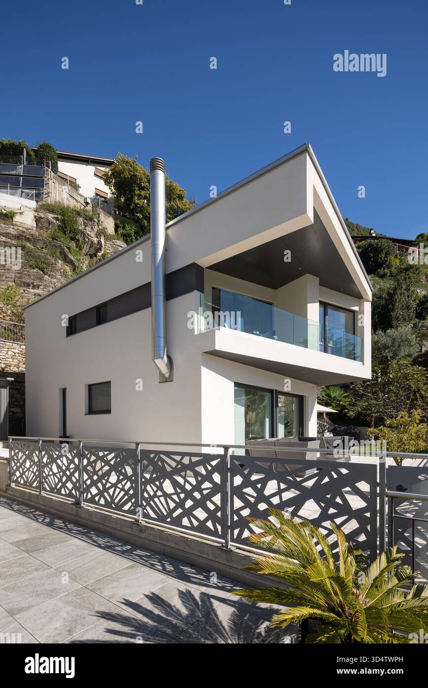 Detail eines modernen weißen Einfamilienhauses mit Terrasse. Sonniger Tag. Stockfoto