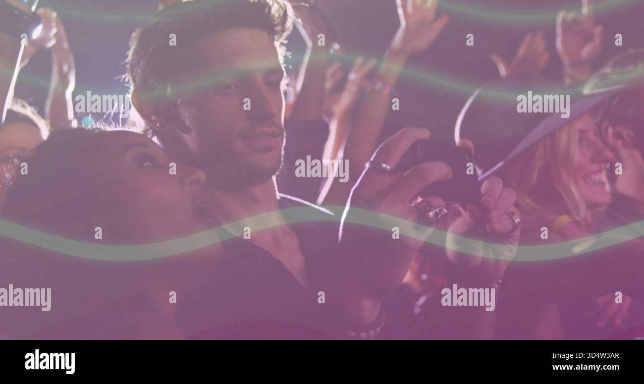 Aufnahme Paar lehnt sich bei Nacht Konzert hält Smartphone mit Schirm Bühnenlicht Linsenstreifen Stockfoto