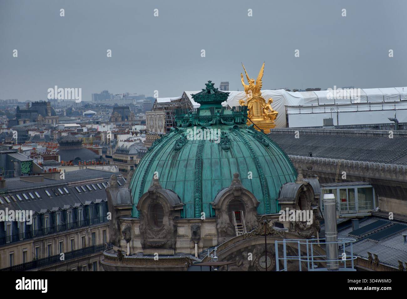 Die grüne Kupferkuppel auf dem Dach der Opéra Garnier in Paris erhebt sich elegant, gekrönt von der goldenen Skulptur der Triumph des Apollo scheint Stockfoto