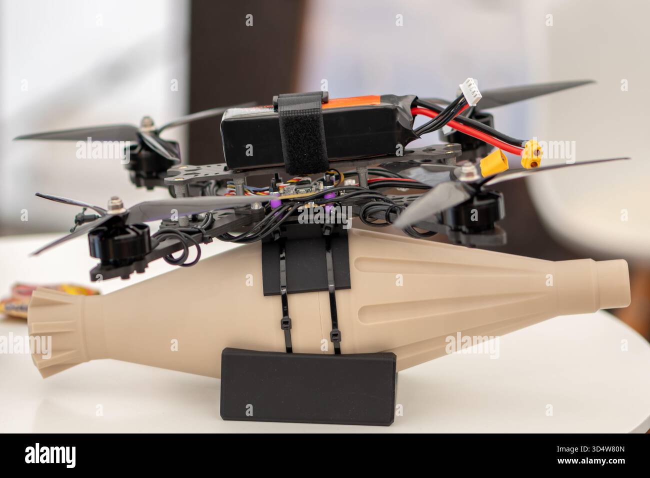 Eine Drohne mit Bombenabwurfausrüstung auf einer Technologieausstellung. Österreich, Wien, 26. Oktober 2025 Stockfoto