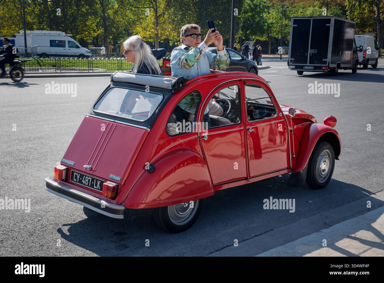 Touristen in einem gemieteten Citroen 2CV halten an, um ein Foto durch das offene Rolldach zu machen, Paris, Frankreich Stockfoto