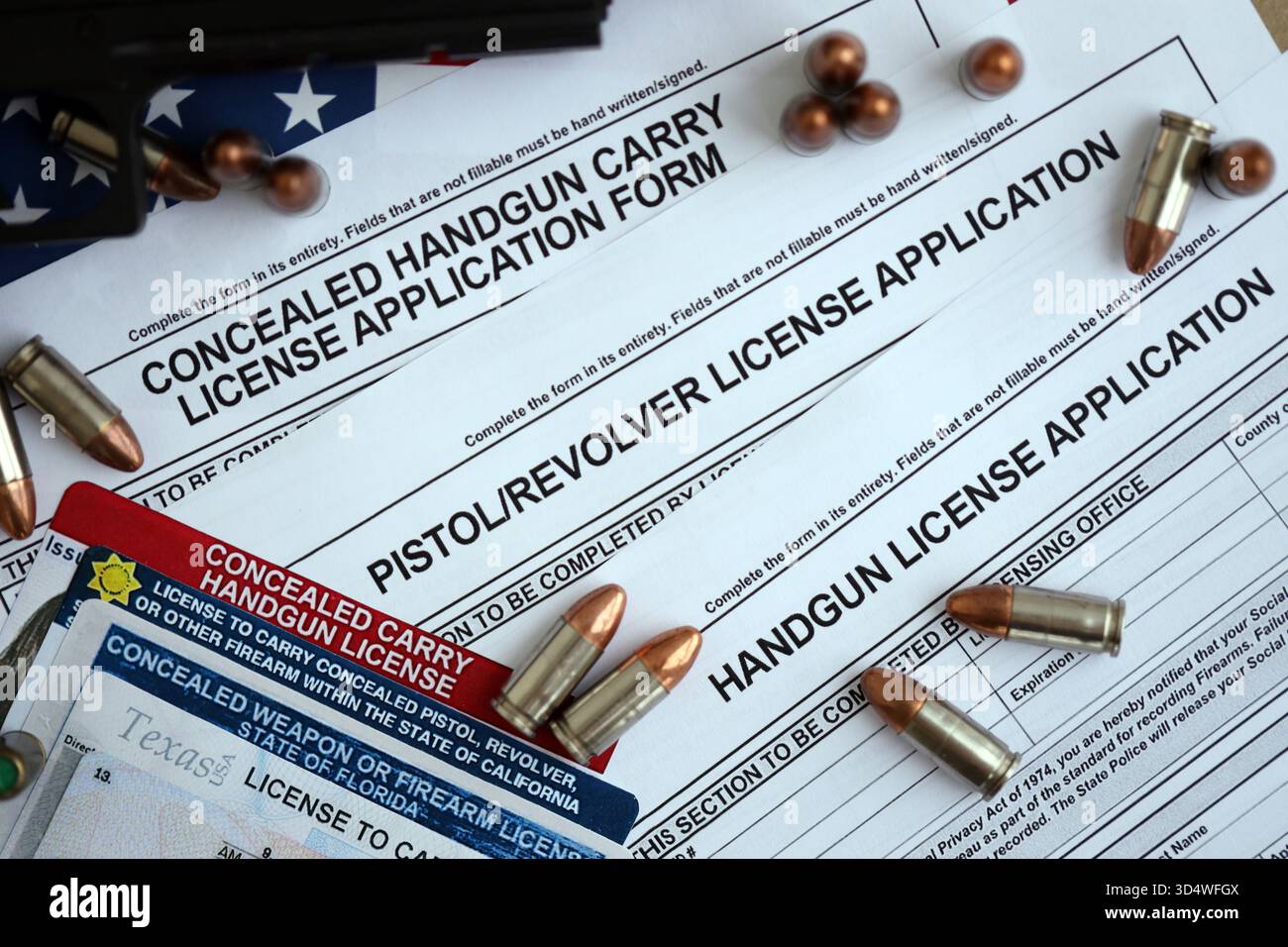 US-Schusswaffenlizenz und Pistole mit Kugeln auf US-Verfassung. Waffenerlaubnis und Verfassung - zweites Zusatzkonzept Stockfoto