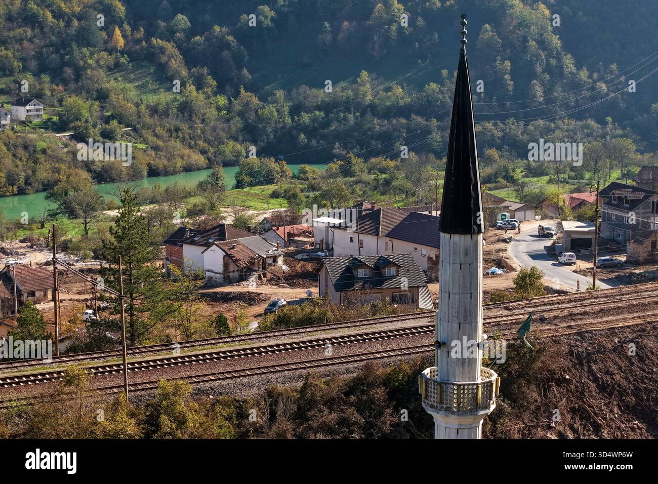 Aus der Vogelperspektive auf ein Minarett, das sich über dem rustikalen Dorf erhebt, eingebettet in sanfte Hügel und einen türkisfarbenen Fluss, Donja Jablanica, Föderation von Bosnien und Herzegowina Stockfoto