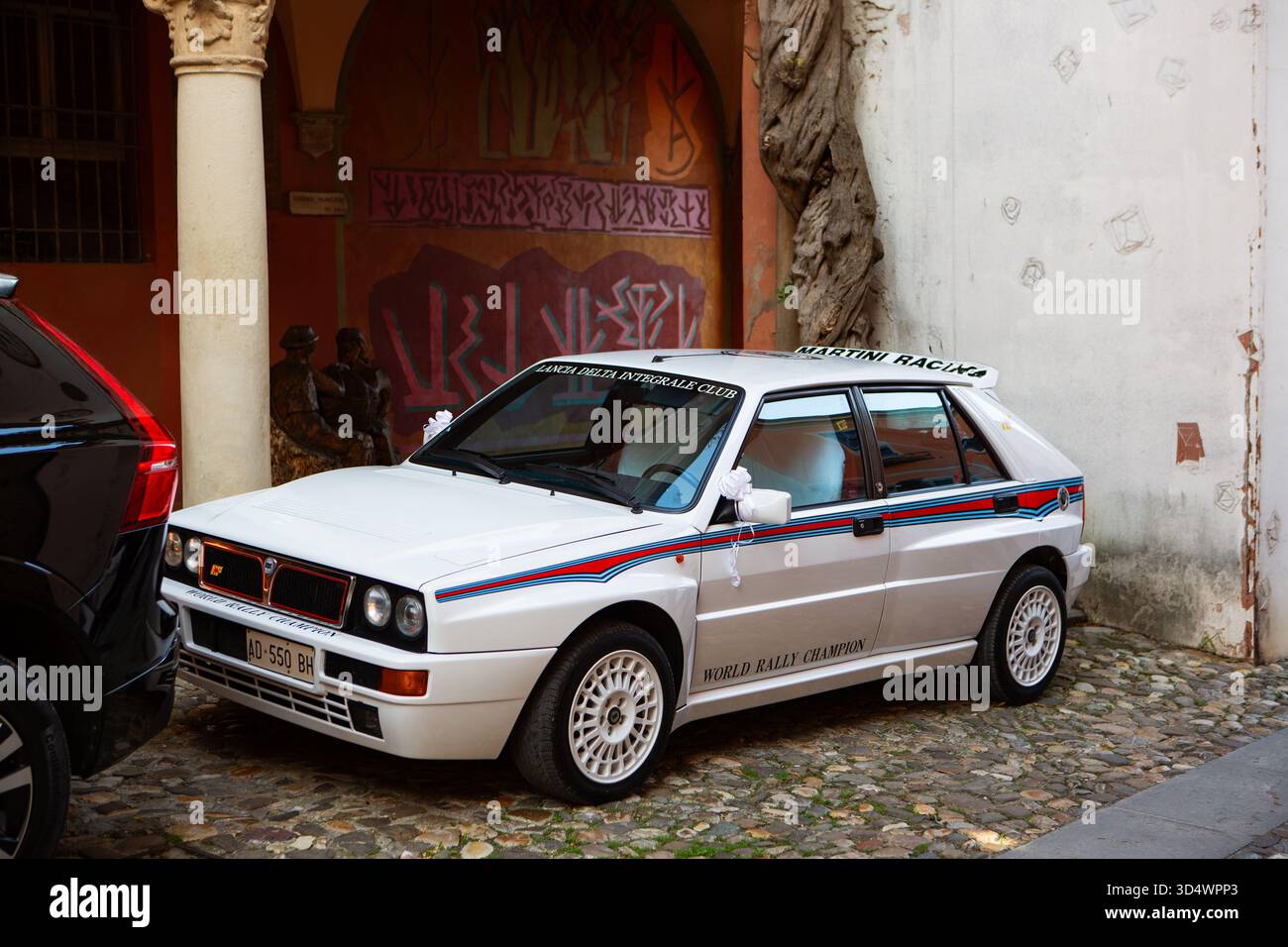 Klassischer Lancia Delta Integrale Rallye-Wagen auf der Kopfsteinpflasterstraße, der italienisches Design und historisches Motorsport-Erbe zeigt. Stockfoto