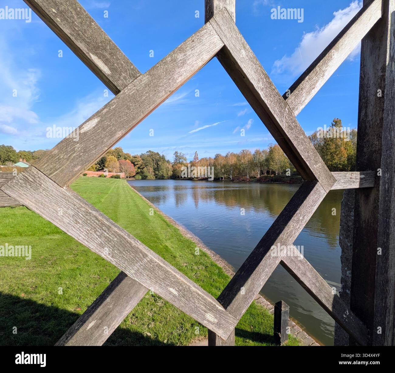 Blick auf den See durch den hölzernen Türrahmen auf Markshall Estate, Essex, England. - Smartphone-aufgenommenes Stockfoto