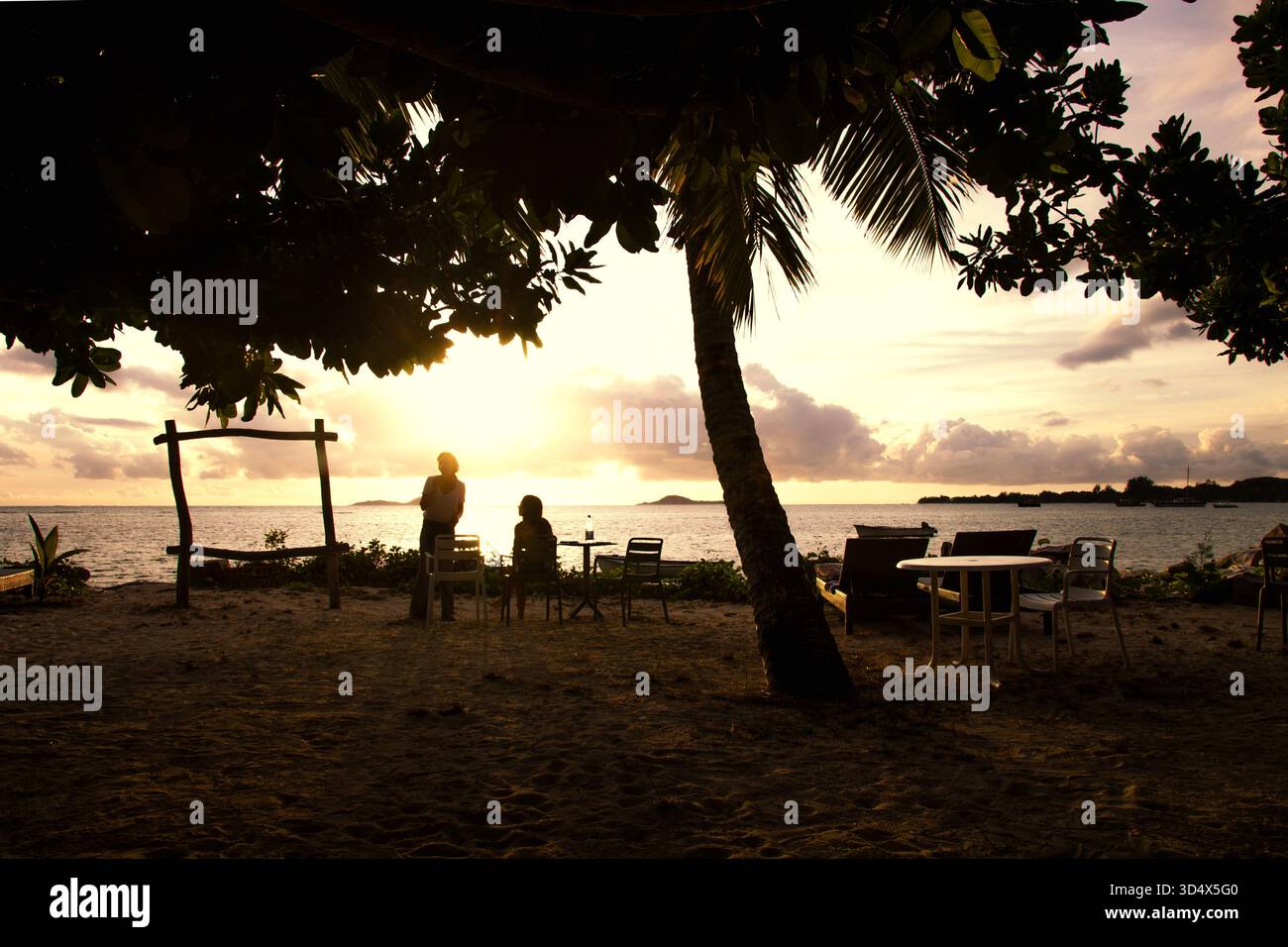 Goldener magischer Sonnenuntergang über dem Strandcafé, Praslin Island, Seychellen Stockfoto