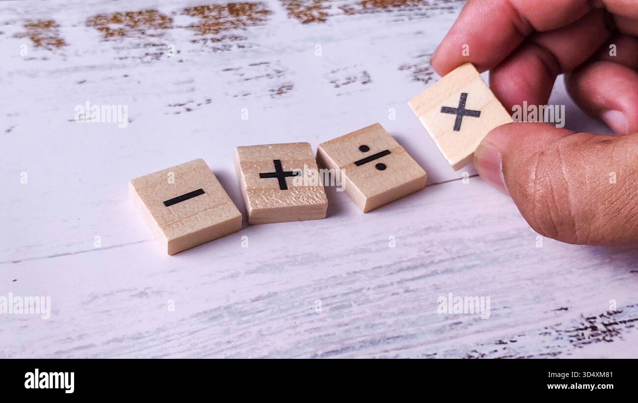 Lösen mathematischer Probleme: Hinzufügung von Symbolen durch Hand mit grundlegenden Operationen Stockfoto