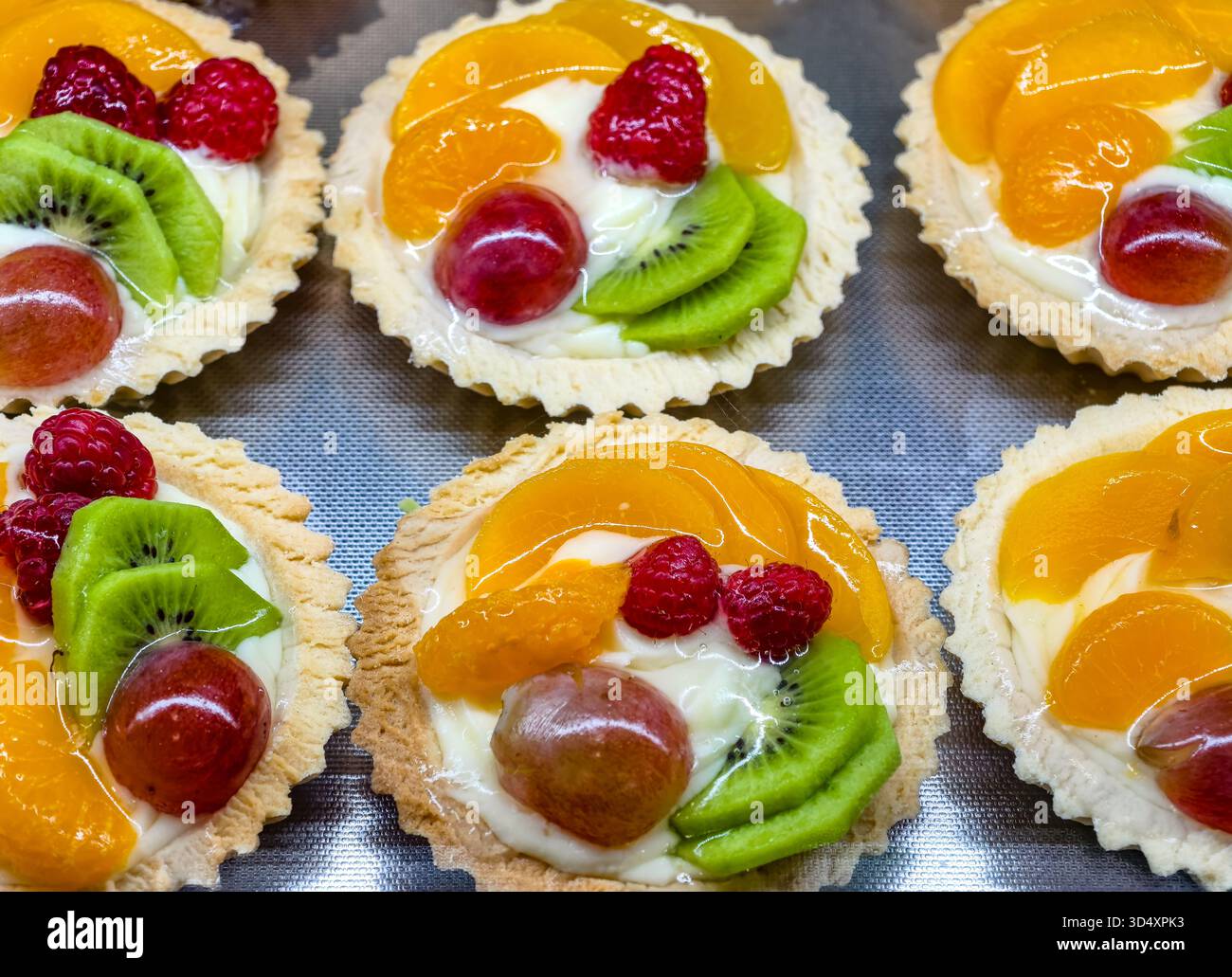Frisches Obst Tartlets Gebäck Creme Display Bunte Dessert Bäckerei Mini Törtchen Kiwi Orange Himbeere Kirsche Gourmet European Patisserie Food Photography Stockfoto