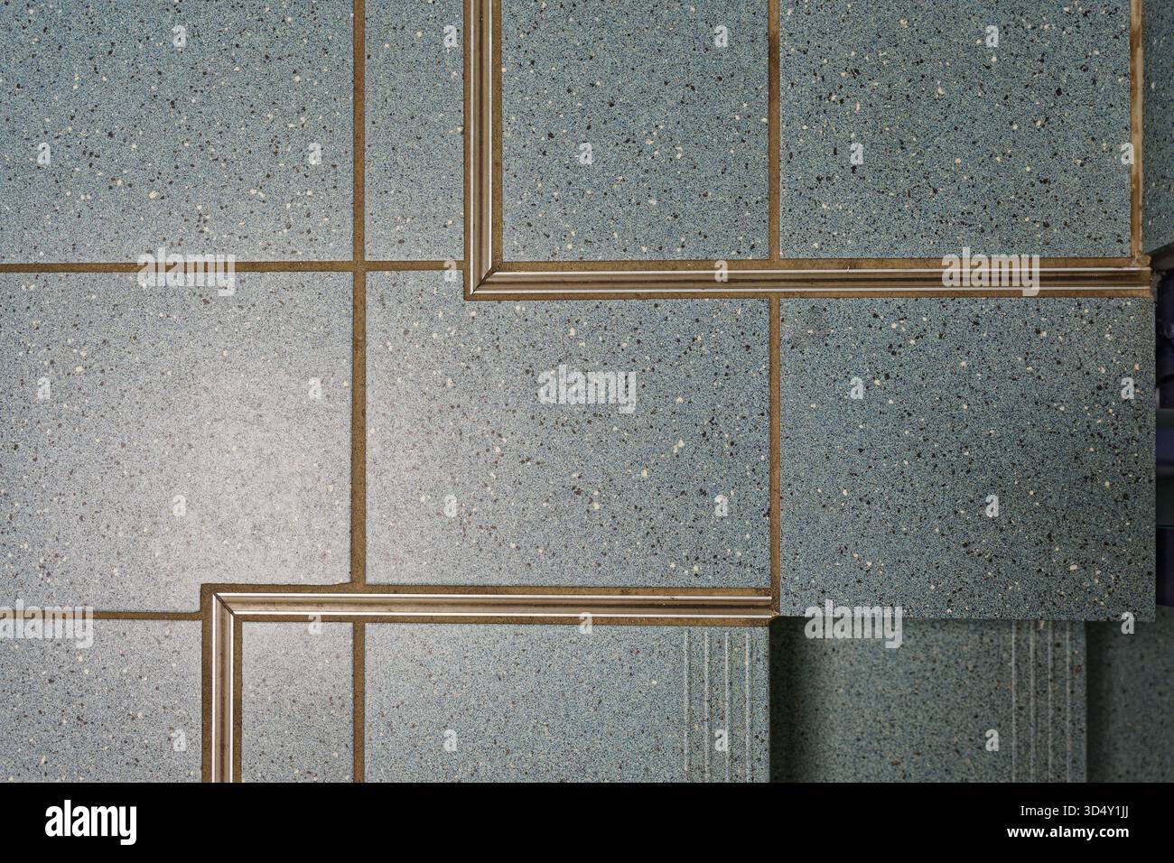 Detailansicht blauer Keramikfliesen mit sauberen Dehnfugen und Metallprofilen, die Präzision in moderner Innenkonstruktion und Handwerk zeigen Stockfoto