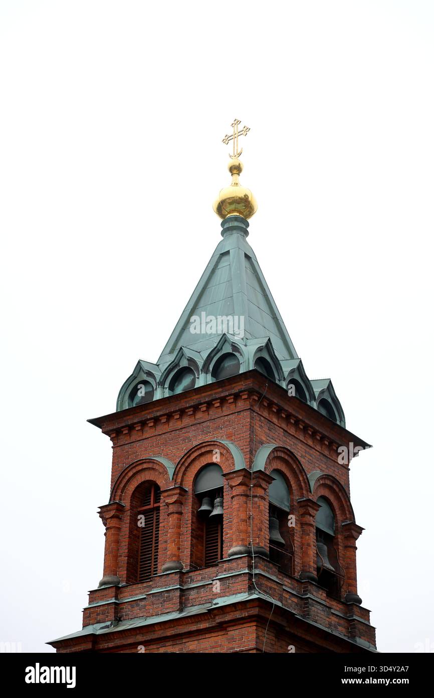 Glockenturm der Uspenski-Kathedrale mit Kupferturm, Zwiebeln und Glocken in Ziegelbögen, Helsinki, Finnland, aufwärts vor einem weißen Himmel fotografiert. Stockfoto