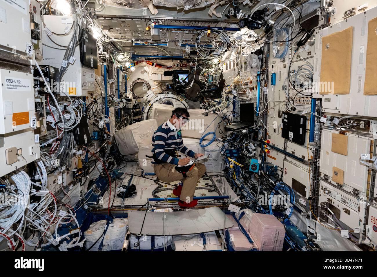 ISS – 22. September 2025 – der Astronaut und Flugingenieur Kimiya Yui der JAXA (Japan Aerospace Exploration Agency) der Expedition 73 macht sich Notizen, während er neue Computer-Netzwerkgeräte im Kibo-Labormodul installiert. Die ethernet-Hub-Upgrades werden Daten schneller und effizienter auf der Internationalen Raumstation übertragen – Foto: Geopix/NASA/Mike Fincke Stockfoto