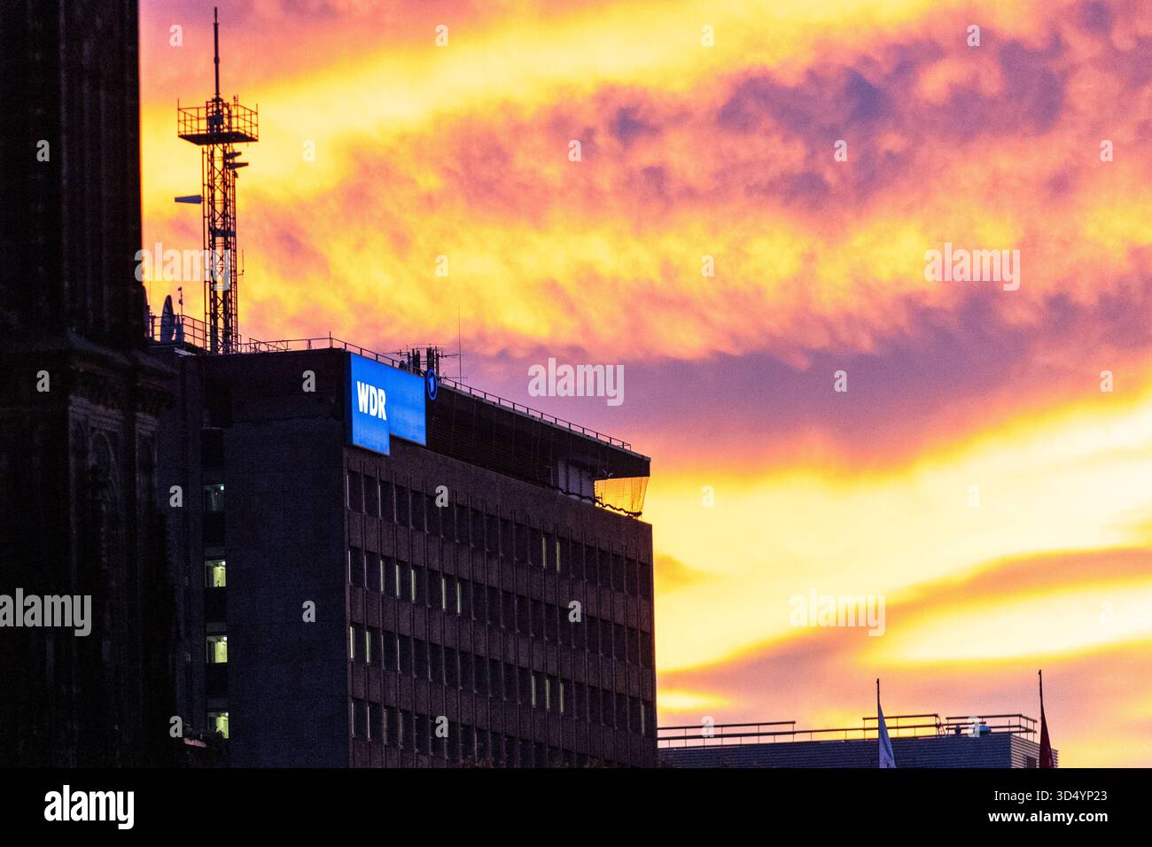 Sonnenuntergang am Kölner Dom Sonnenuntergang zwischen dem Kölner Dom und dem Hauptbahnhof mit Blick auf das Gebäude des WDR Filmarchivs, welches das Markante WDR-Logo des Westdeutschen Rundfunks trägt. Köln Deutschland *** Sonnenuntergang am Kölner Dom Sonnenuntergang zwischen dem Kölner Dom und dem Hauptbahnhof mit Blick auf das WDR-Filmarchiv, das das unverwechselbare WDR-Logo des Westdeutschen Rundfunks Köln Deutschland trägt Copyright: XBonn.digitalx/xMarcxJohnx Stockfoto