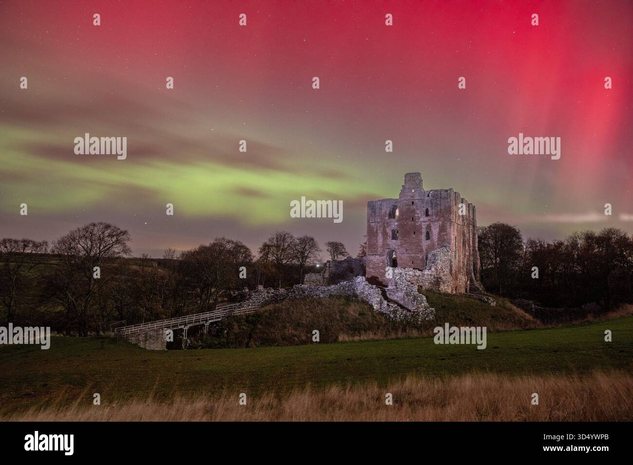 Die Nordlichter (Aurora Borealis) über den Ruinen von Norham Castle Stockfoto