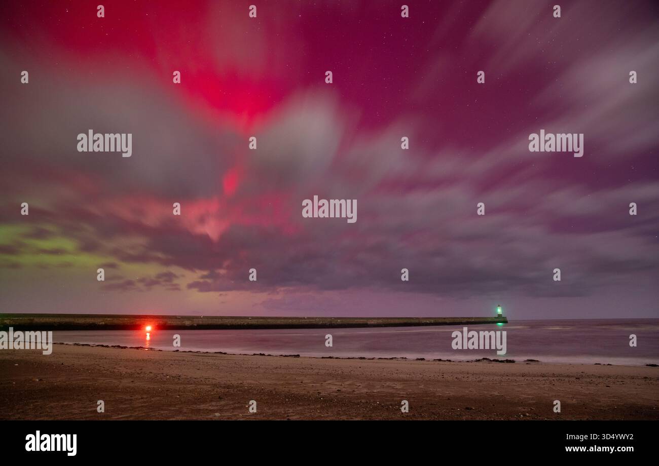 Die Nordlichter (Aurora Borealis) über Berwick Pier und Lighthouse, die in den frühen Morgenstunden des 12. November 2025 über den Wolken sichtbar sind Stockfoto