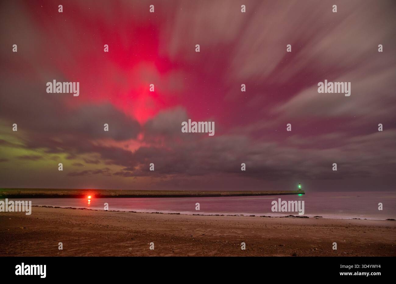 Die Nordlichter (Aurora Borealis) über Berwick Pier und Lighthouse, die in den frühen Morgenstunden des 12. November 2025 über den Wolken sichtbar sind Stockfoto