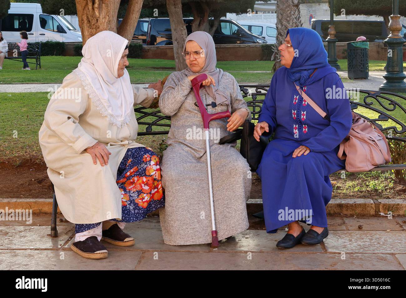 Freunde sprechen auf einer Parkbank in Rabat, Marokko Stockfoto