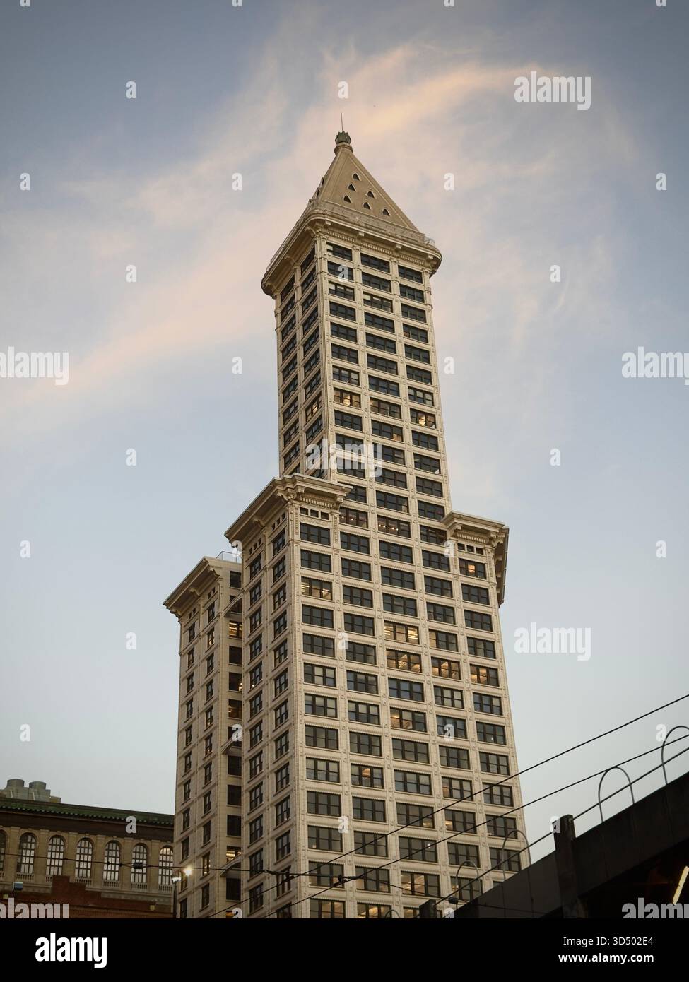 Ein historischer Wolkenkratzer, der hoch vor einem weichen Abendhimmel von seattle steht und Architektur mit zeitlosen Skylines verbindet. - Smartphone-aufgenommenes Stockfoto