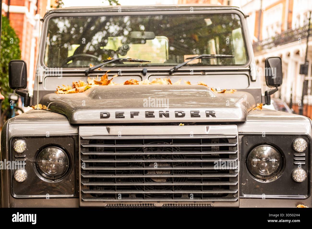 LONDON - 15. OKTOBER 2025: Land Rover Defender parkte in der Kensington Street mit Autumn Leaves, London 4x4 Stockfoto