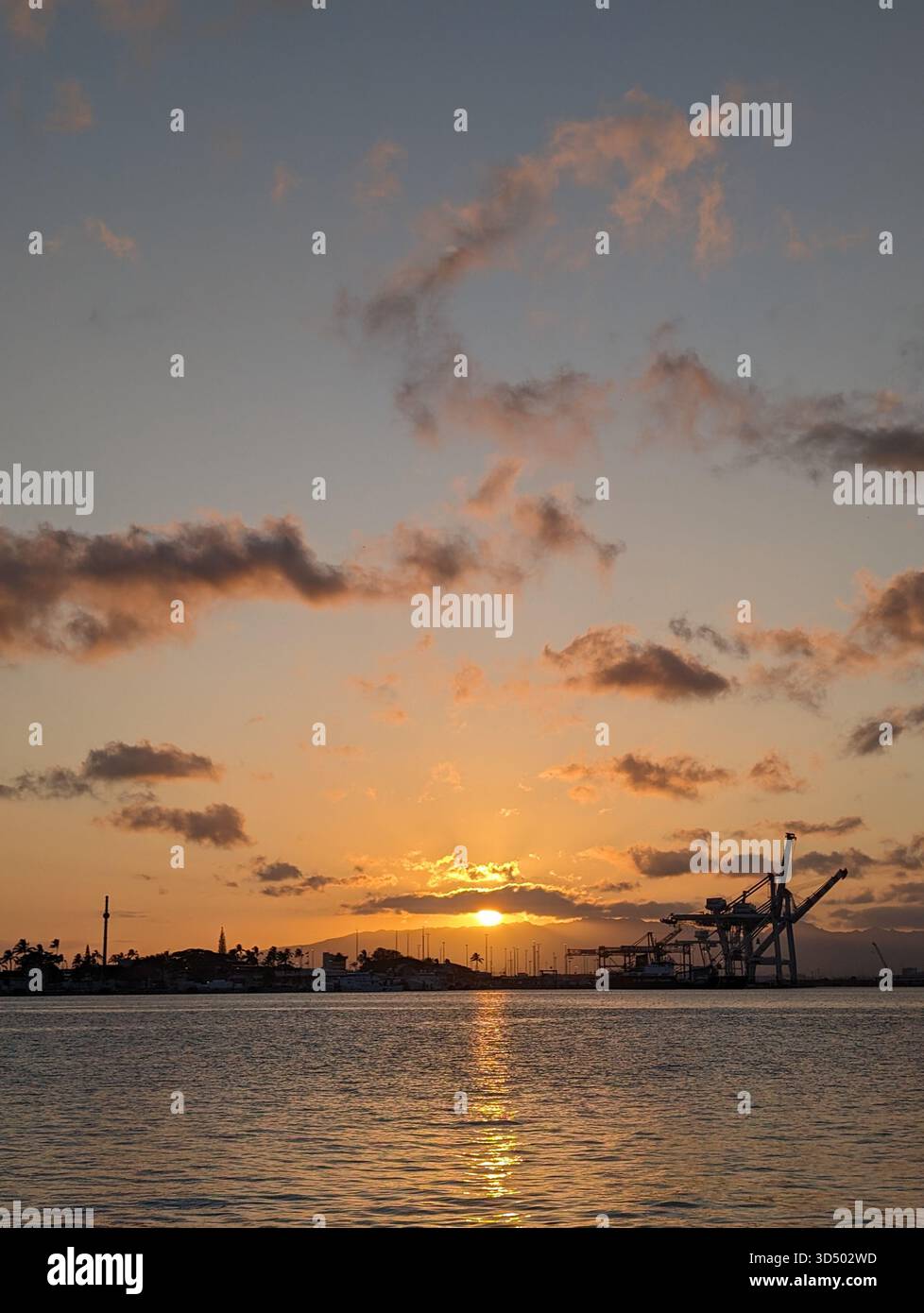 Ein industrieller hawaiianischer Sonnenuntergang, wo Natur auf den Menschen trifft. - Smartphone-aufgenommenes Stockfoto