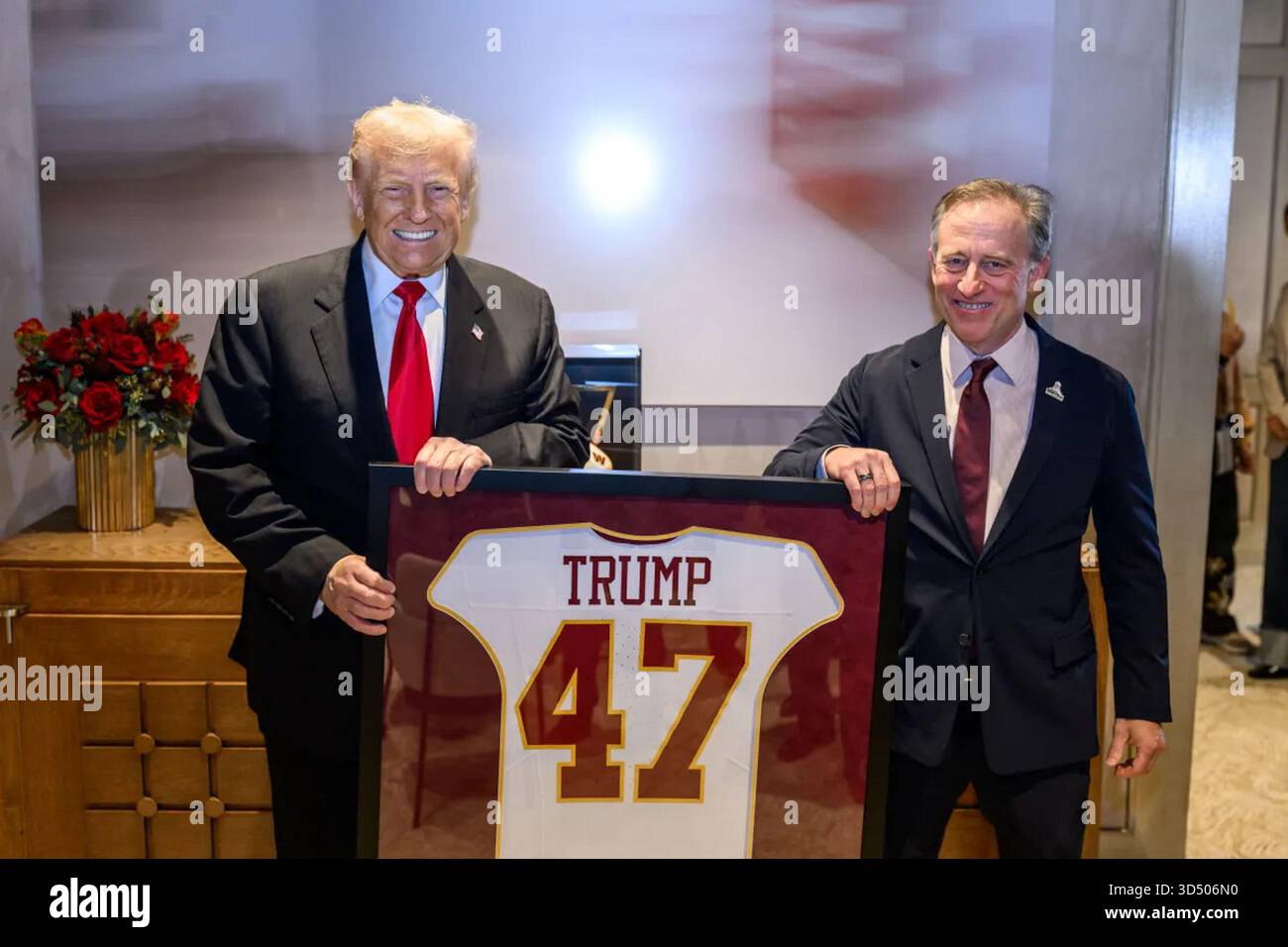 Präsident Donald J. Trump wird vor dem NFL-Spiel gegen die Detroit Lions im Northwest Stadium in Landover, Maryland mit einem gerahmten Washington Commanders Trikot mit seinem Namen und der Nummer 47 präsentiert. November 2025. Bild mit freundlicher Genehmigung des Weißen Hauses. Stockfoto