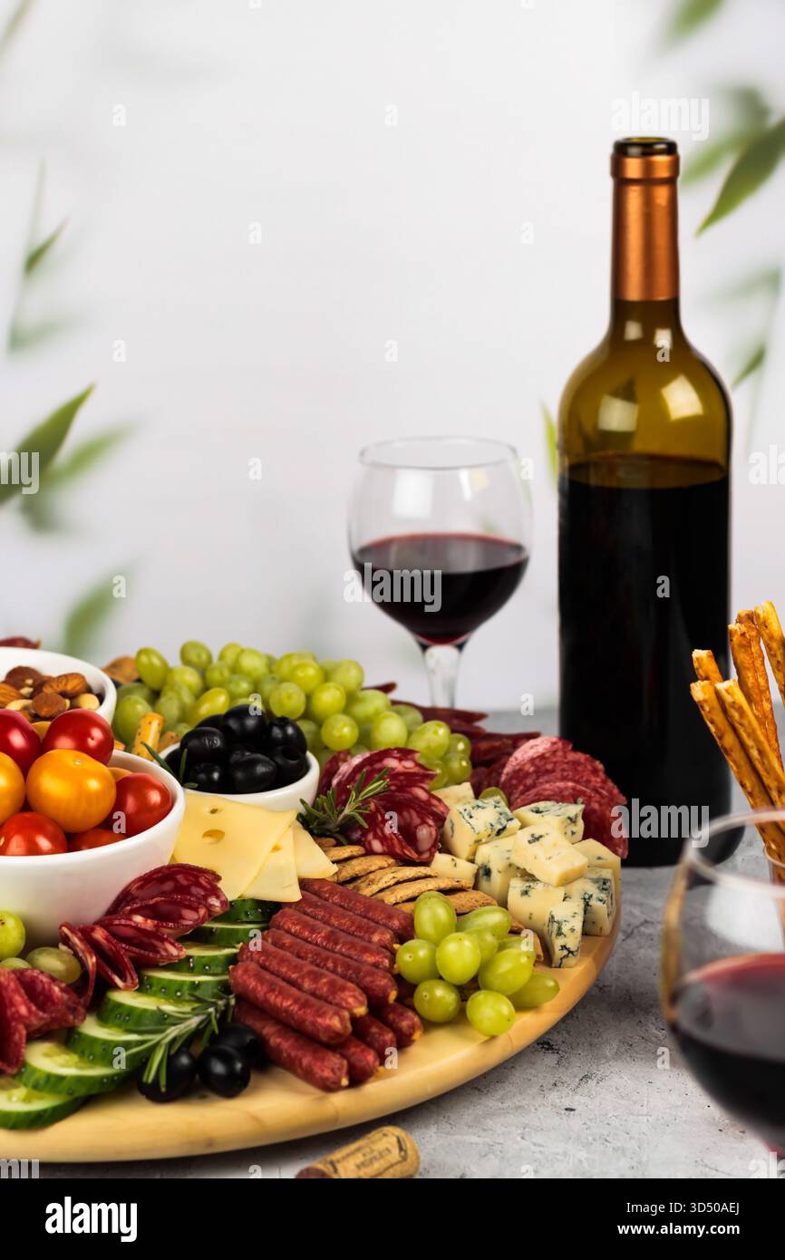 Eine farbenfrohe Wurstplatte bietet eine Vielzahl von Aufschnitt, Käse und frischem Obst, die ordentlich angeordnet sind. Stockfoto
