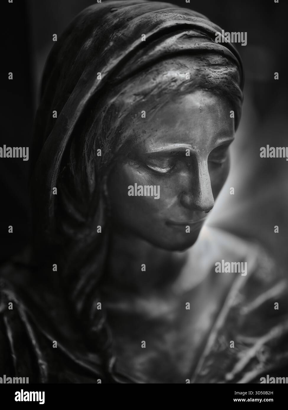 Schwarz-weißes Nahporträt einer weiblichen Steinstatue mit einem ruhigen, kontemplativen Ausdruck Stockfoto