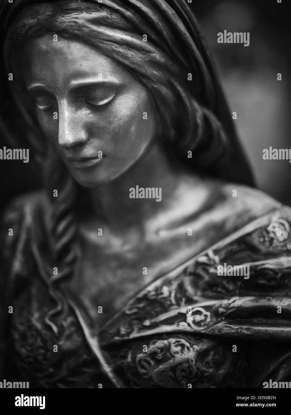 Schwarz-weißes Nahporträt einer weiblichen Steinstatue mit einem ruhigen, kontemplativen Ausdruck Stockfoto