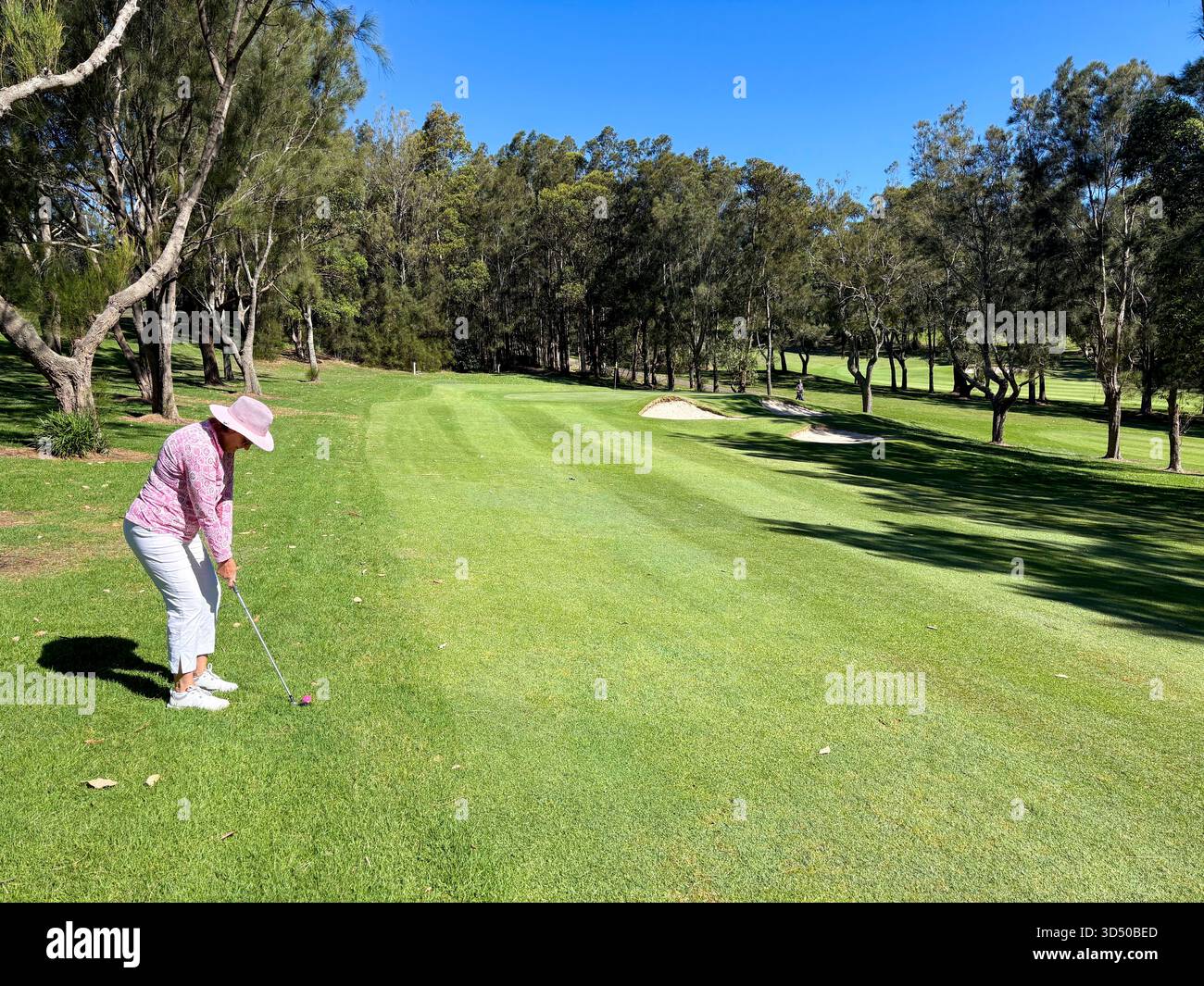 Lady Model hat Golfspieler mit einem Eisen auf dem Fairway in Richtung Grün, Avalon Beach, Sydney, Australien, veröffentlicht - Smartphone-aufgenommenes Stockfoto