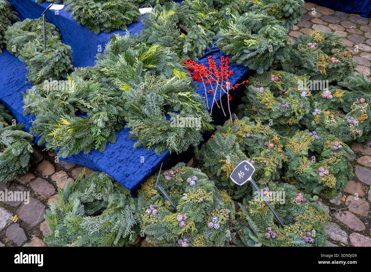 Wunderschöne handgefertigte Weihnachtskränze oder Girlanden aus Kiefernzweigen zur Dekoration, die im Winter auf einem Straßenmarkt ausgestellt werden Stockfoto