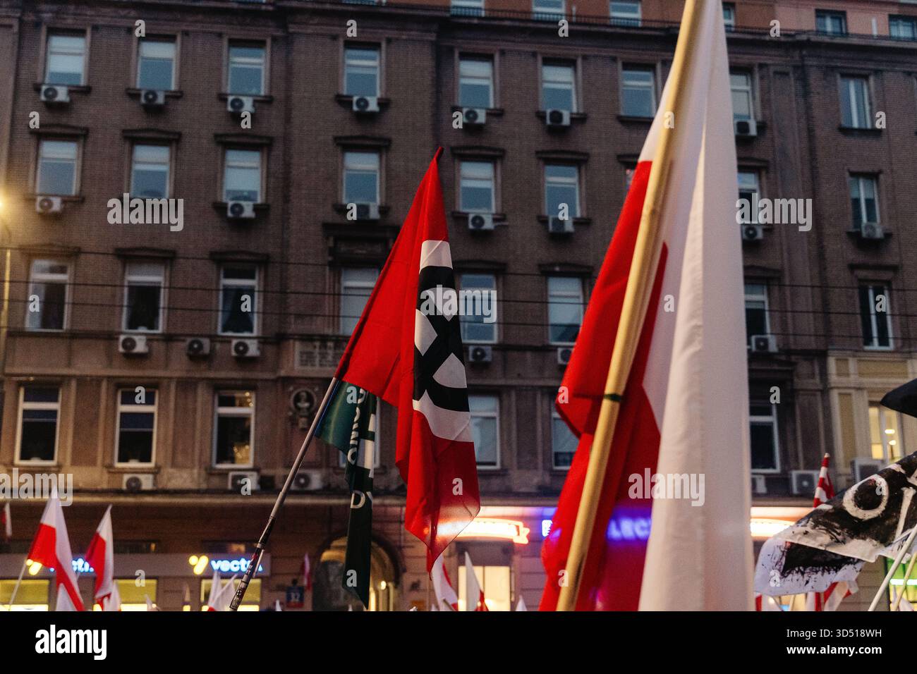 Ein Nationalist schwingt eine Flagge mit dem keltischen Kreuz, das während des Protestes das Nazi-Symbol der weißen Vorherrschaft auf der ganzen Welt ist. Die Polen feiern den Nationalen Unabhängigkeitstag, um die Wiedererlangung der Unabhängigkeit des Landes nach 123 Jahren Teilung im Jahr 1918 zu feiern. 16 Jahre lang findet jährlich ein unabhängigkeitsmarsch durch die Straßen statt, der von der nationalistischen und rechten Independence March Association organisiert wird. Dieses Jahr findet der marsch unter dem Motto "eine Nation - starkes Polen " statt, und die Veranstaltung befasst sich ausführlich mit der Frage der Migration als Bedrohung für die nationale Einheit. Stockfoto