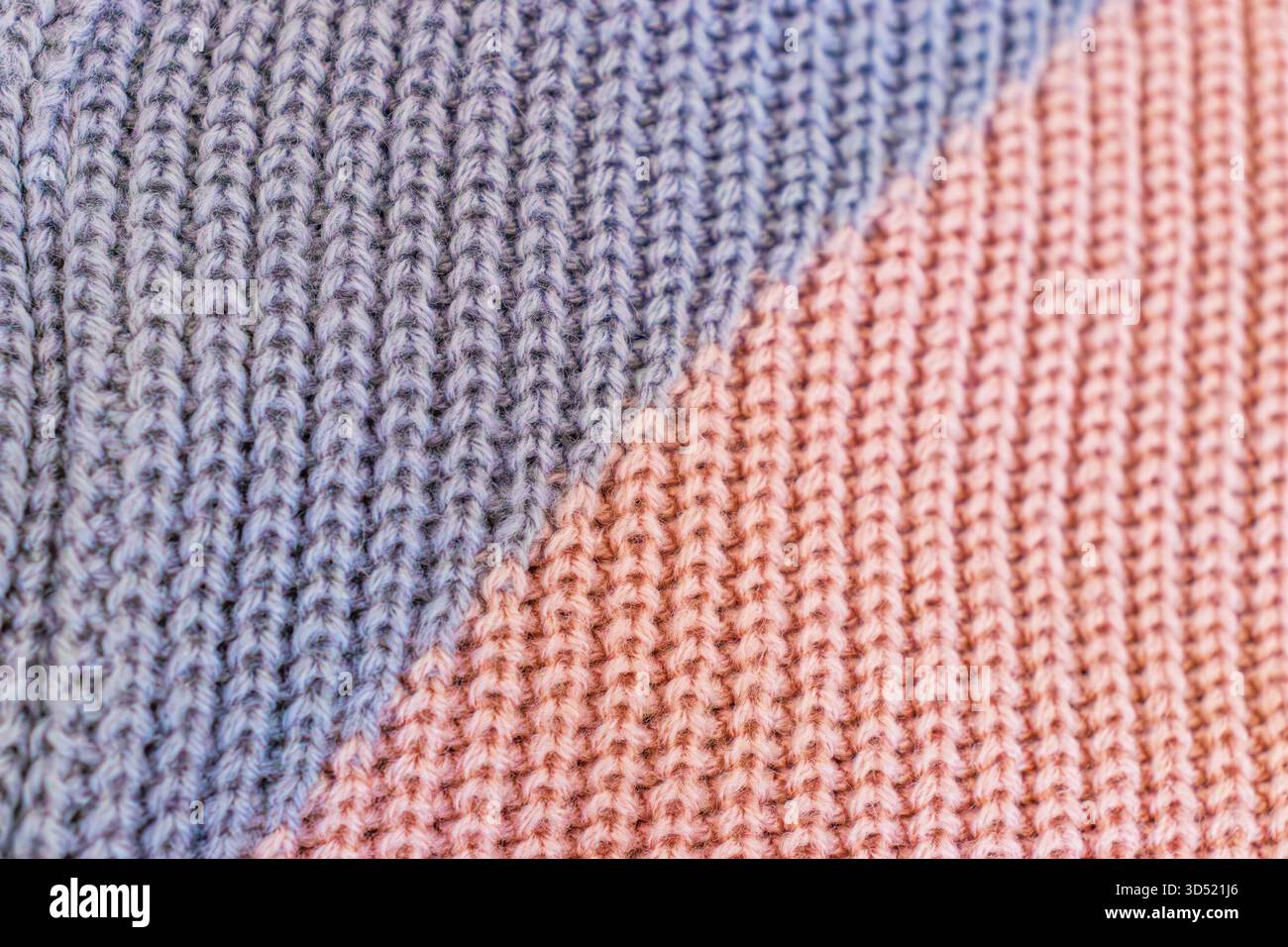 Makrofoto von Strickgewebe aus rosa und violettem Garn. Stockfoto