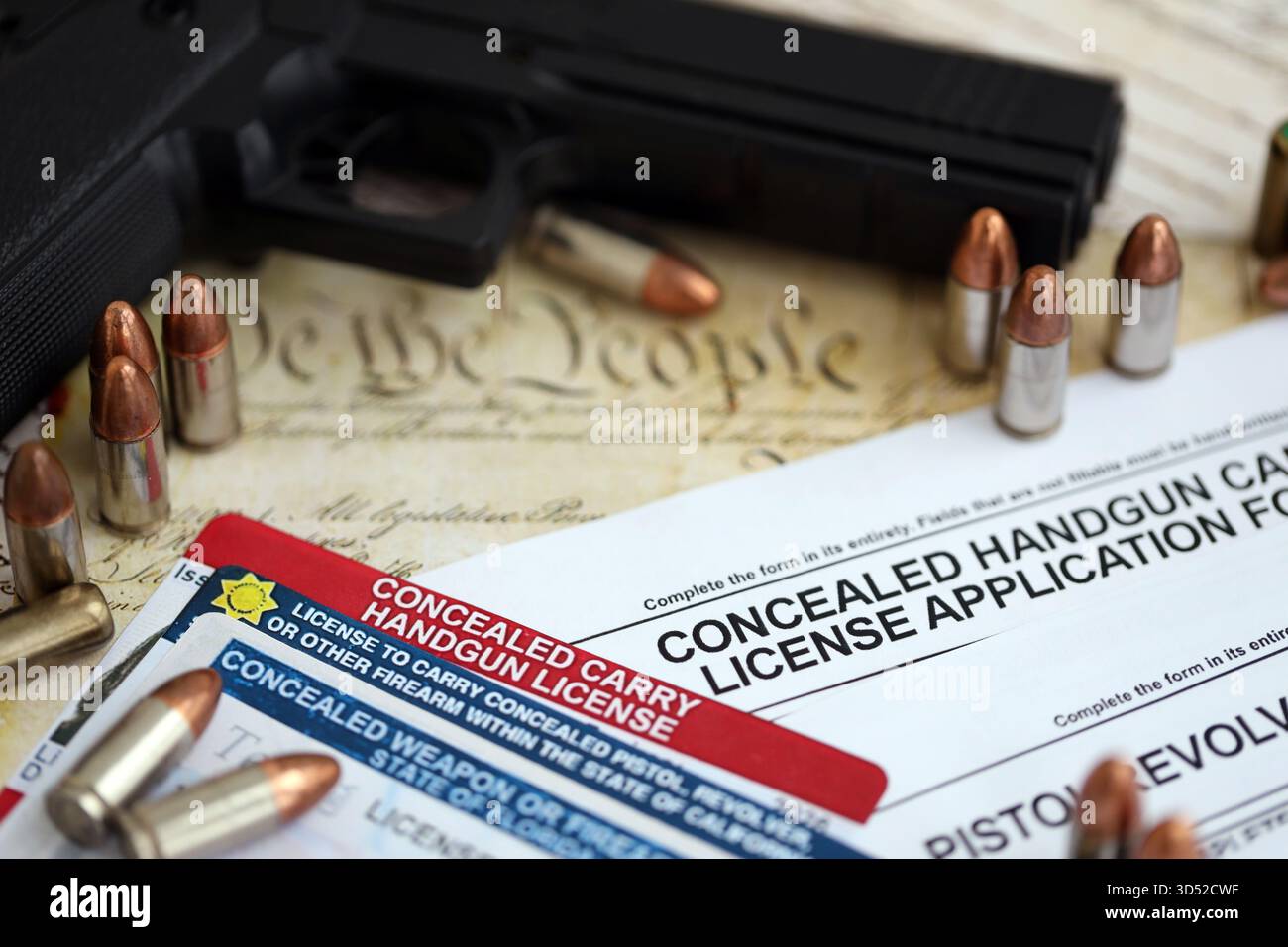 US-Schusswaffenlizenz und Pistole mit Kugeln auf US-Verfassung. Waffenerlaubnis und Verfassung - zweites Zusatzkonzept Stockfoto