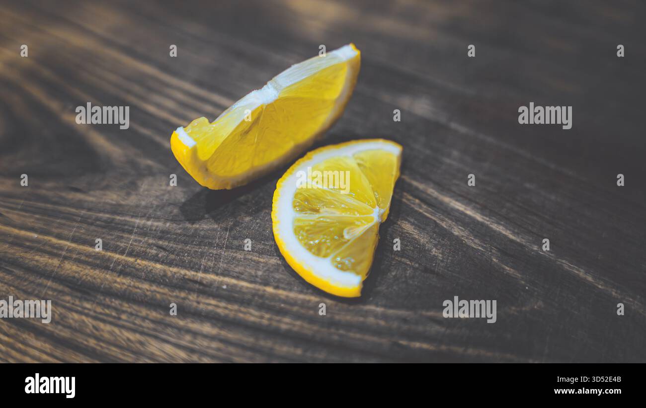 Saftige Zitronenscheiben auf einem rustikalen Holzbrett. Lebendige Farben und natürliche Textur sorgen für Frische und Einfachheit Stockfoto