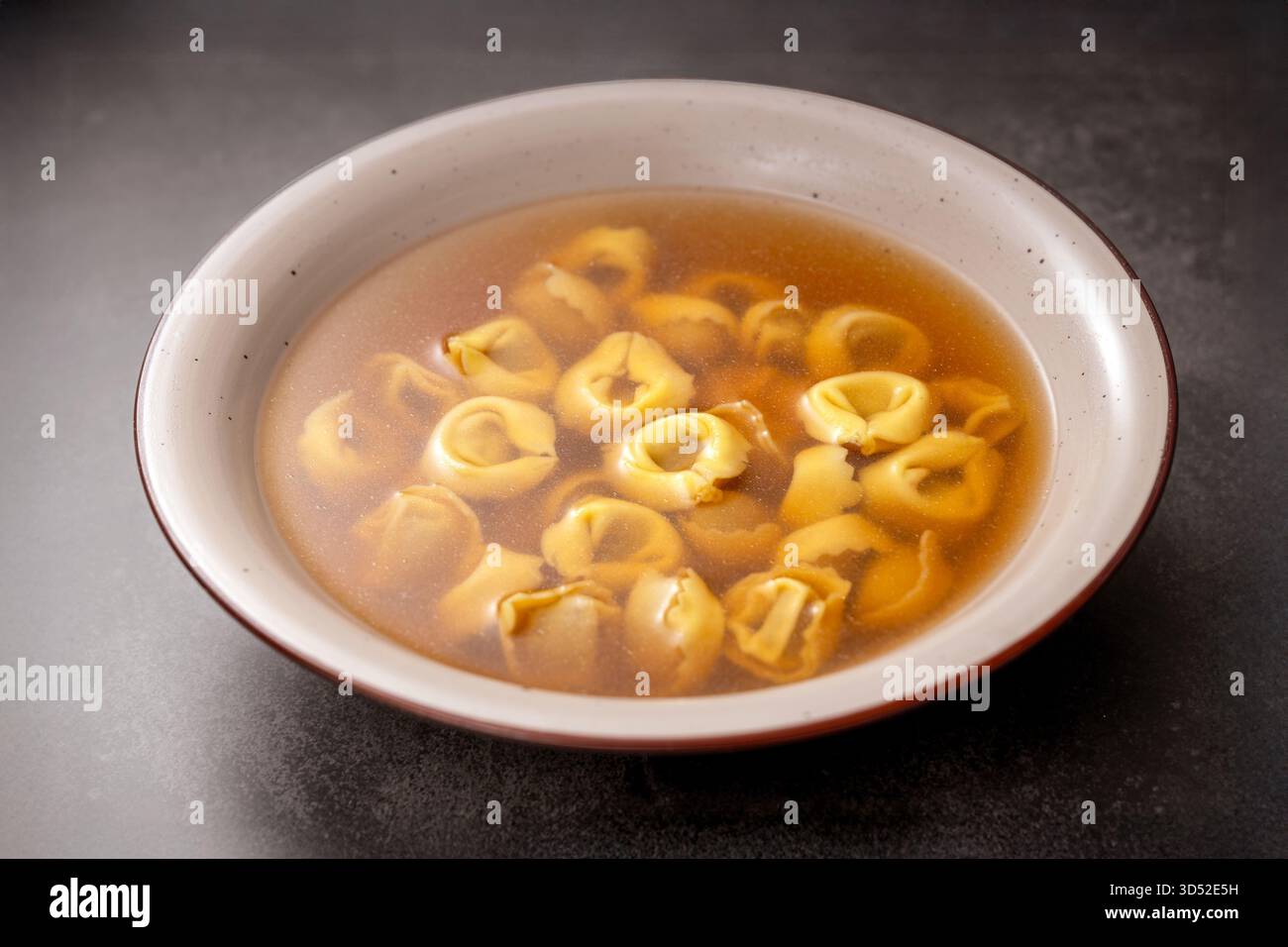 Tortellini in Brodo, eine klassische italienische Pasta in klarer, herzhafter Brühe, die traditionelles, komfortables Essen repräsentiert Stockfoto