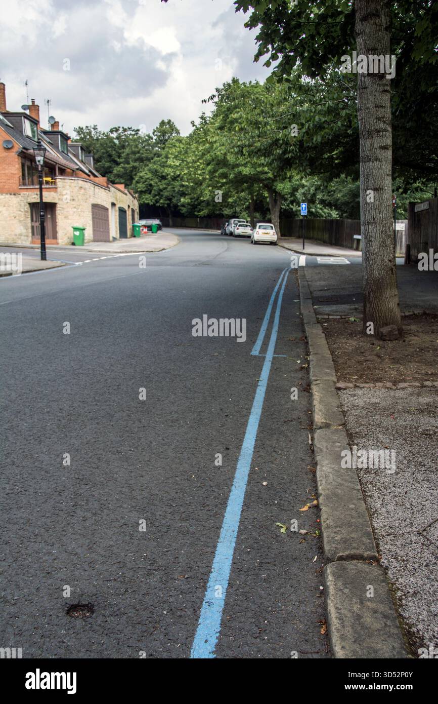 Beispiel für Beschränkungen für Privatparkplätze auf der Straße, die durch doppelte blaue Linien (kein Parken für Fahrzeuge) und eine blaue Linie (Fahrzeuge mit Genehmigung) gekennzeichnet sind Stockfoto